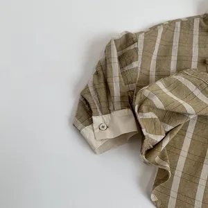 Close-up of olive green and white striped cotton fabric texture and buttoned sleeve cuff