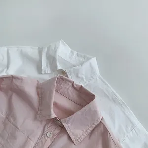 Détail des cols classiques et des boutons blancs sur les chemises en coton blanc et rose