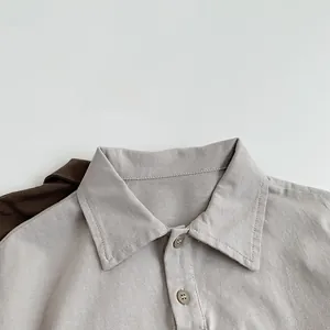 Gros plan du col pointu classique et des boutons d'un polo gris en coton pour enfants