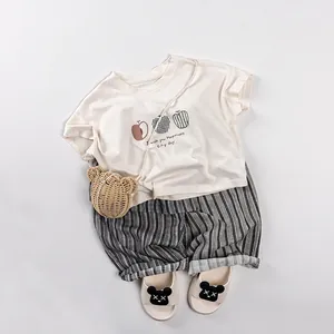 Kids summer casual set with striped shorts and cream t-shirt featuring apple prints