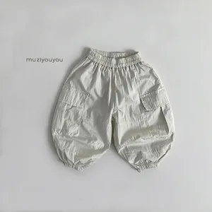 Detailed view of beige cargo joggers featuring elastic waist and utility flap pockets