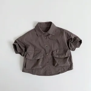 Detailed flat lay of children's short sleeve cotton shirt with large utility pockets