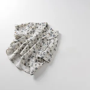 Detailed flat lay of children's short sleeve shirt with colorful pebble print and front pocket