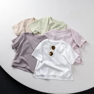 Close-up of pastel cotton kids T-shirts featuring a minimalist round neck and side slit hem