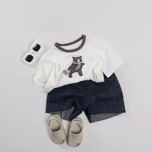 Tenue d'été pour enfants à plat avec T-shirt blanc imprimé ours et short en jean