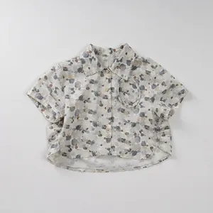 Detailed macro of the child shirt's abstract pebble print and natural cotton linen texture