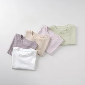 Detailed flat lay of five colorful cotton T-shirts in soft pastel macaron shades