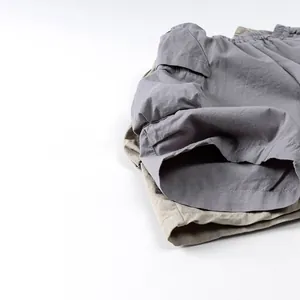 Détail de shorts cargo gris et kaki montrant la texture respirante en coton et lin naturel