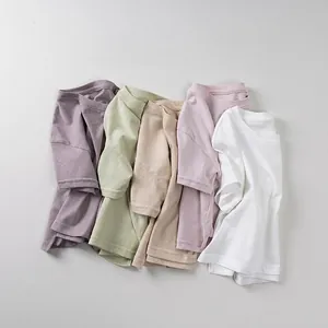 Five assorted colors of kids cotton t-shirts in soft pastel tones for summer
