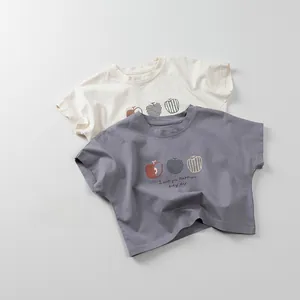 Flat lay of cotton kids t-shirts in beige and blue featuring three apple graphic prints