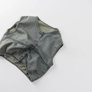 Detail view of children's light wash denim vest with metal buttons and soft texture
