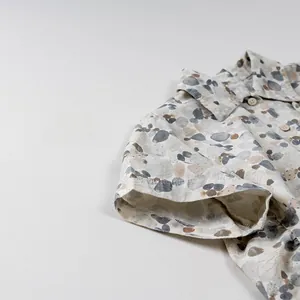 Detail of short sleeve shirt with stone pattern print and natural wood buttons