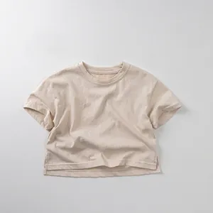 Detail view of beige cotton kids T-shirt showing side slit and minimalist fabric texture