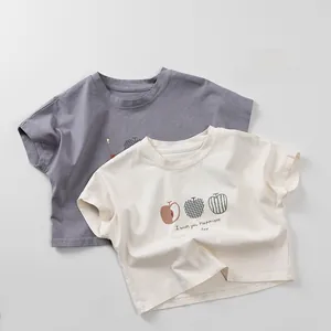Detail view of children's cotton T-shirts with artistic apple prints and smooth necklines