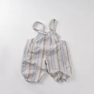 Détail de salopette rayée pour bébé en coton et lin avec boutons blancs ronds