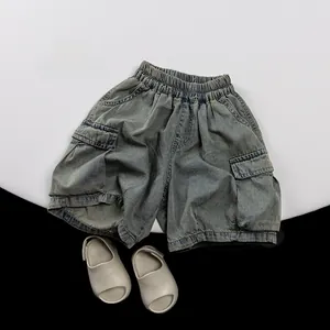 Detail of kids denim cargo shorts with elastic waist and large side pockets on a white stand