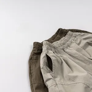Flachbild von atmungsaktiven Kinder-Baumwollhosen in Oliv und Beige mit elastischem Bund