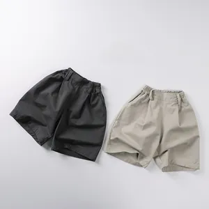 Dettaglio dei pantaloncini in cotone per bambini con elastico in grigio e beige