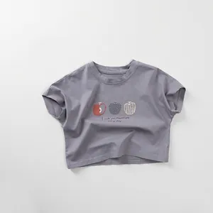 Close-up of cotton kids T-shirt featuring artistic apple prints and positive lettering