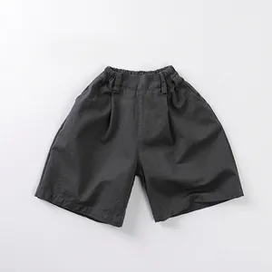 Dettaglio dei pantaloncini in cotone grigio scuro con vita elastica e tasche laterali