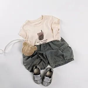 Kids summer outfit with beige cotton t-shirt and grey denim shorts in casual style