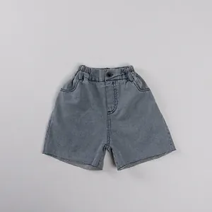 Détail d'un short en jean enfant avec taille élastique et bords effilochés tendance