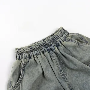 Detailed close-up of elastic waistband and vintage washed denim fabric on kids shorts