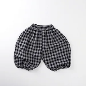 Macro view of black and grey gingham checked cotton kids harem pants with elastic cuffs