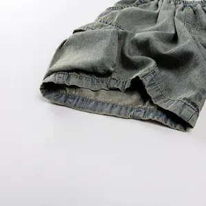 Detail view of children's washed denim shorts featuring elastic waist and utility side pocket