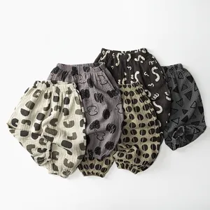 Close-up of five pairs of cotton gauze kids pants with various minimalist patterns