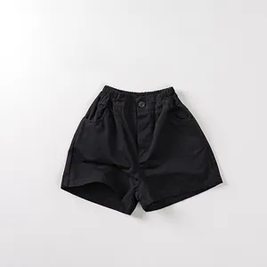 Detail of children's black cotton shorts featuring an elastic waist and side pockets