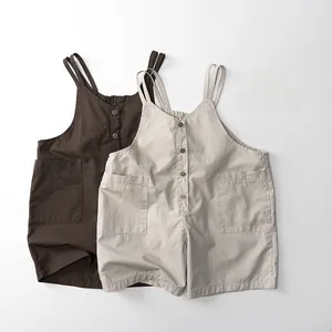 Détail de la salopette pour enfants avec boutons en bois et grandes poches plaquées