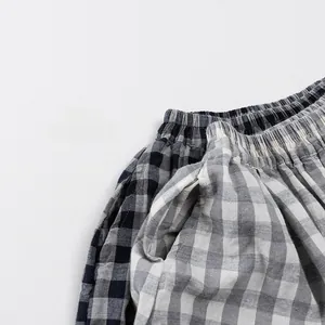 Detailed view of elastic waist and pockets on cotton plaid lightweight summer kids pants