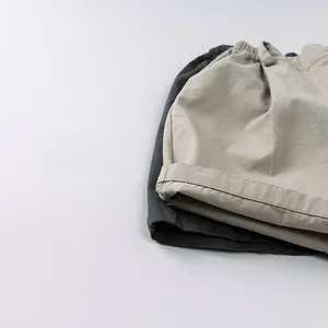 Dettaglio di pantaloncini in cotone per bambini in kaki e grigio scuro con elastico