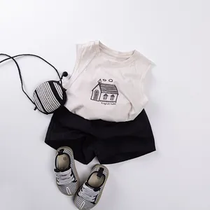 Flat lay of kids summer set featuring beige tank top and black cotton shorts