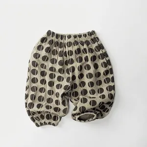 Detailed view of kids breathable cotton pants with black polka dots and elastic cuffs