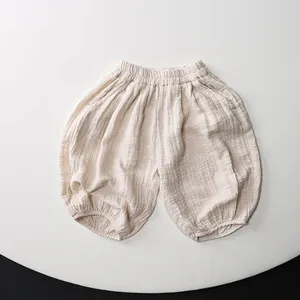 Detailed macro view of cream-colored kids' cotton bloomers with elastic waistband and cuffs