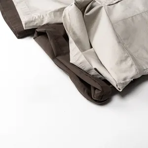 Détail des ourlets retroussés sur un short à bretelles en nylon marron et beige texturé