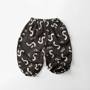 Detail of breathable double-layer cotton gauze trousers for kids with abstract print