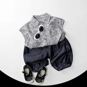 Tenue d'été pour garçons avec chemise fleurie grise, short foncé, lunettes et sandales