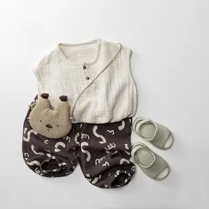 Flat lay of double-layer cotton gauze trousers for kids with bear bag and sandals