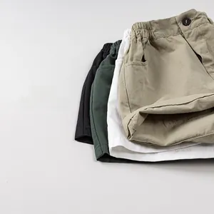Close-up of cotton kids' shorts in khaki, white, green and black with elastic waist details