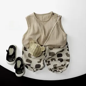 Flat lay of breathable double-layer cotton toddler summer outfit with khaki top and printed pants