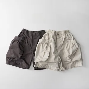 Détail de short cargo enfant en coton avec grandes poches plissées et taille élastique