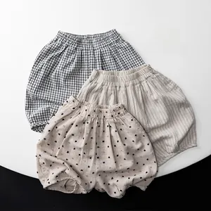 Close-up of three patterns of linen baby bloomers: grid, stripes, and polka dots