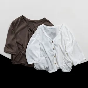 Close-up of lightweight kids cotton cardigan showing V-neck and vintage wooden buttons