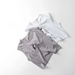 Flat lay of two soft cotton toddler tank tops in grey and purple with penguin prints