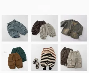 Vue à plat de divers pantalons en coton pour enfants et veste en jean en tons terre
