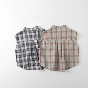Close-up of children plaid sleeveless shirts showing back pleat detail in gray and orange