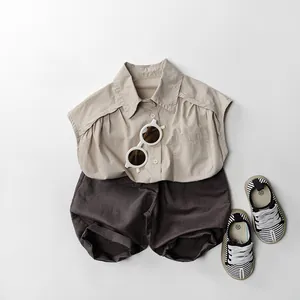 Mise à plat d'une chemise sans manches beige avec un short marron et des chaussures rayées